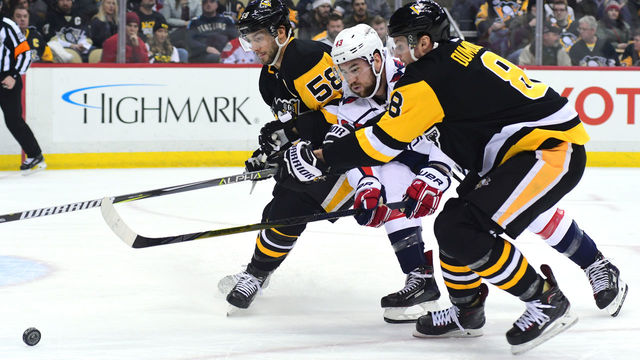PITTSBURGH, PA - FEBRUARY 02: Brian Dumoulin #8 of the Pittsburgh Penguins fights for the puck against Tom Wilson #43 of the Washington Capitals at PPG PAINTS Arena on February 2, 2018 in Pittsburgh, Pennsylvania.