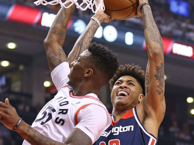 TORONTO, ON - APRIL 17: Kelly Oubre Jr. #4 of the Washington Wizards goes up and over Delon Wright #55 of the Toronto Raptors for a basket in Game Two of the Eastern Conference First Round in the 2018 NBA Play-offs at the Air Canada Centre on April 17, 2018 in Toronto, Ontario, Canada. The Raptors defeated the Wizards 130-119.
