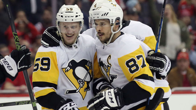 WASHINGTON, DC - APRIL 26: Jake Guentzel #59 of the Pittsburgh Penguins (l) celebrates his game winning goal at 7:48 of the third period against the Washington Capitals and is joined by Sidney Crosby #87 (r) in Game One of the Eastern Conference Second Round during the 2018 NHL Stanley Cup Playoffs at the Capital One Arena on April 26, 2018 in Washington, DC. The Penguins defeated the Capitals 3-2.