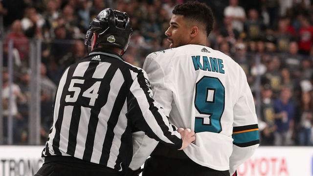 GLENDALE, NV - APRIL 26: Evander Kane #9 of the San Jose Sharks is escorted off the ice by linesman Greg Devorski #54 after a 5 minute major penalty and game misconduct in the third period Game One of the Western Conference Second Round against the Vegas Golden Knights during the 2018 NHL Stanley Cup Playoffs at T-Mobile Arena on April 26, 2018 in Las Vegas, Nevada. The Golden Knights defeated the Sharks 7-0.