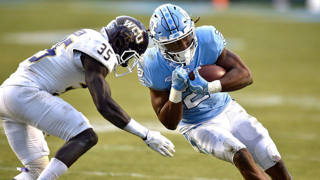 CHAPEL HILL, NC - NOVEMBER 18: Jordon Brown #2 of the North Carolina Tar Heels runs with the ball against Keion Crossen #35 of the Western Carolina Catamounts at Kenan Stadium on November 18, 2017 in Chapel Hill, North Carolina.