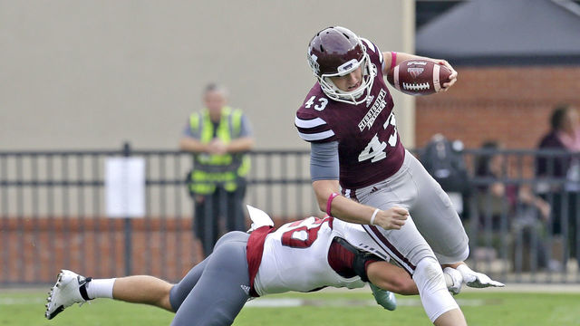 STARKVILLE, MS - OCTOBER 10: Punter Logan Cooke #43 of the Mississippi State Bulldogs runs around linebacker Mitchell Roland #26 of the Troy Trojans for a first down on a fake punt during the first quarter of a NCAA college football game at Davis Wade Stadium on October 10, 2015, in Starkville, Mississippi.
