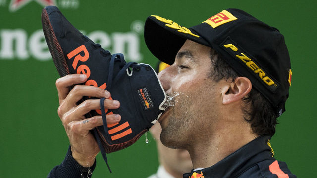 TOPSHOT - Red Bull's Australian driver Daniel Ricciardo drinks champagne out of his shoe as he celebrates on the podium after winning the Formula One Chinese Grand Prix in Shanghai on April 15, 2018. / AFP PHOTO / Johannes EISELE