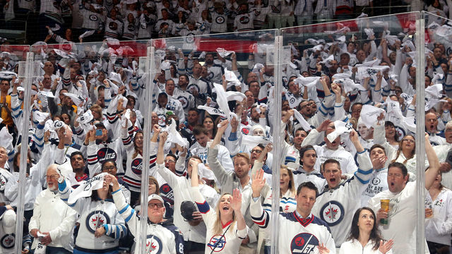 WINNIPEG, MB - MAY 1: Winnipeg Jets fans clad in all white rise to their feet and cheer prior to puck drop between the Jets and the Nashville Predators in Game Three of the Western Conference Second Round during the 2018 NHL Stanley Cup Playoffs at the Bell MTS Place on May 1, 2018 in Winnipeg, Manitoba, Canada.