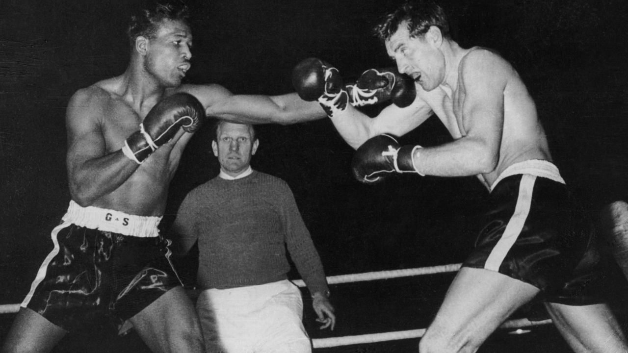 American middleweight boxer Sugar Ray Robinson (1921 - 1989, left) lands a straight left on former German middleweight champion Hans Stretz during a match in Frankfurt, 25th December 1950. Robinson won the fight by technical knock-out in the fifth round.