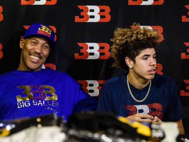 LaVar Ball (L), father of basketball player LiAngelo Ball and the owner of the Big Baller brand, sits with his other son LaMelo Ball during a promotional event in Hong Kong on November 14, 2017. UCLA players LiAngelo Ball -- the younger brother of Los Angeles Lakers rookie star Lonzo Ball -- and teammates Cody Riley and Jalen Hill were arrested on November 7 in Hangzhou ahead of their regular-season-opening game against Georgia Tech in nearby Shanghai this past weekend. ESPN reported that they were nabbed on suspicion of stealing from a Louis Vuitton store and later freed on bail but ordered to remain in Hangzhou. / AFP PHOTO / Anthony WALLACE