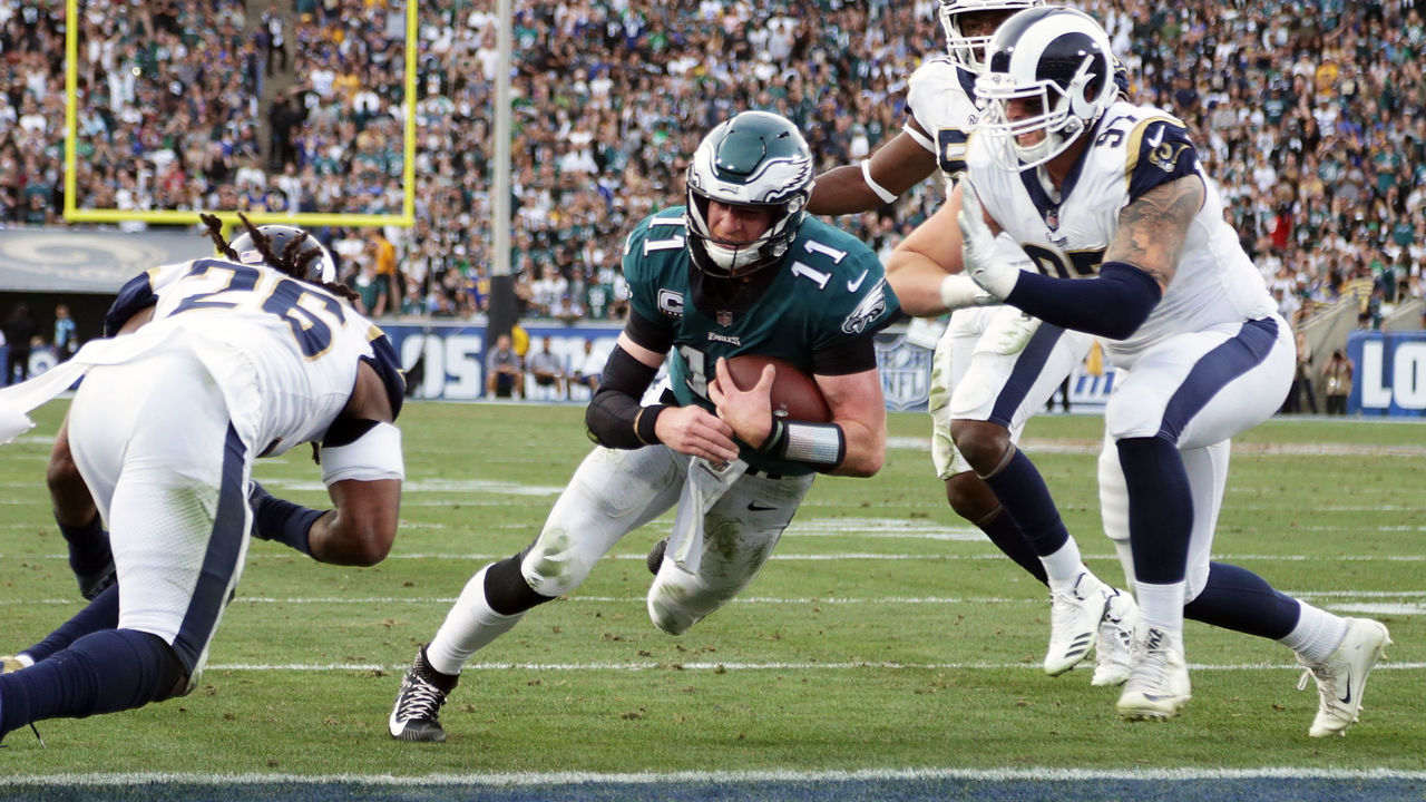 LOS ANGELES, CA - DECEMBER 10: Carson Wentz #11 of the Philadelphia Eagles is hit by Mark Barron #26 of the Los Angeles Rams during the third quarter of the game. Wentz was later escorted off the field due to a knee injury at the Los Angeles Memorial Coliseum on December 10, 2017 in Los Angeles, California.