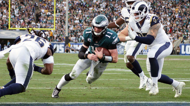 LOS ANGELES, CA - DECEMBER 10: Carson Wentz #11 of the Philadelphia Eagles is hit by Mark Barron #26 of the Los Angeles Rams during the third quarter of the game. Wentz was later escorted off the field due to a knee injury at the Los Angeles Memorial Coliseum on December 10, 2017 in Los Angeles, California.