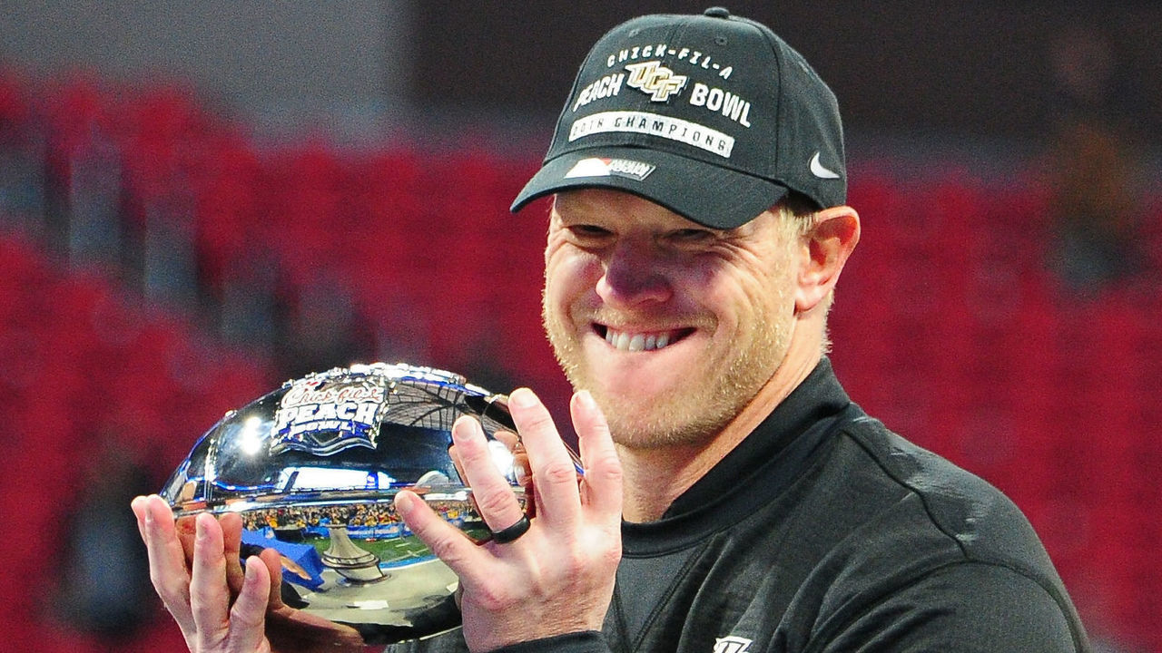 ATLANTA, GA - JANUARY 1: Head Coach Scott Frost of the Central Florida Knights accepts the championship trophy for winning the Chick-fil-A Peach Bowl against the Auburn Tigers on January 1, 2018 in Atlanta, Georgia.