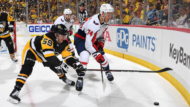 PITTSBURGH, PA - MAY 01: Jake Guentzel #59 of the Pittsburgh Penguins and John Carlson #74 of the Washington Capitals battle for the loose puck in Game Three of the Eastern Conference Second Round during the 2018 NHL Stanley Cup Playoffs at PPG Paints Arena on May 1, 2018 in Pittsburgh, Pennsylvania.