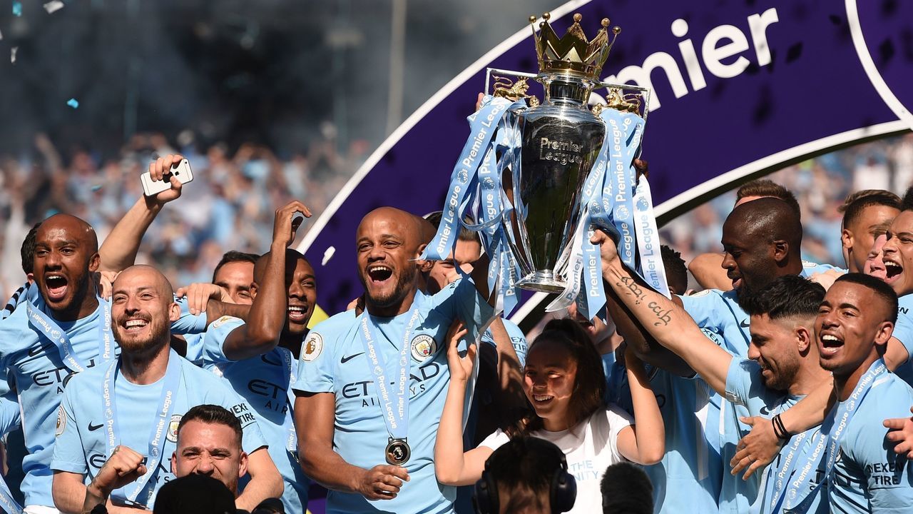 Manchester City's captian, Belgian defender Vincent Kompany lifts the Premier League trophy on the pitch after the English Premier League football match between Manchester City and Huddersfield Town at the Etihad Stadium in Manchester, north west England, on May 6, 2018.