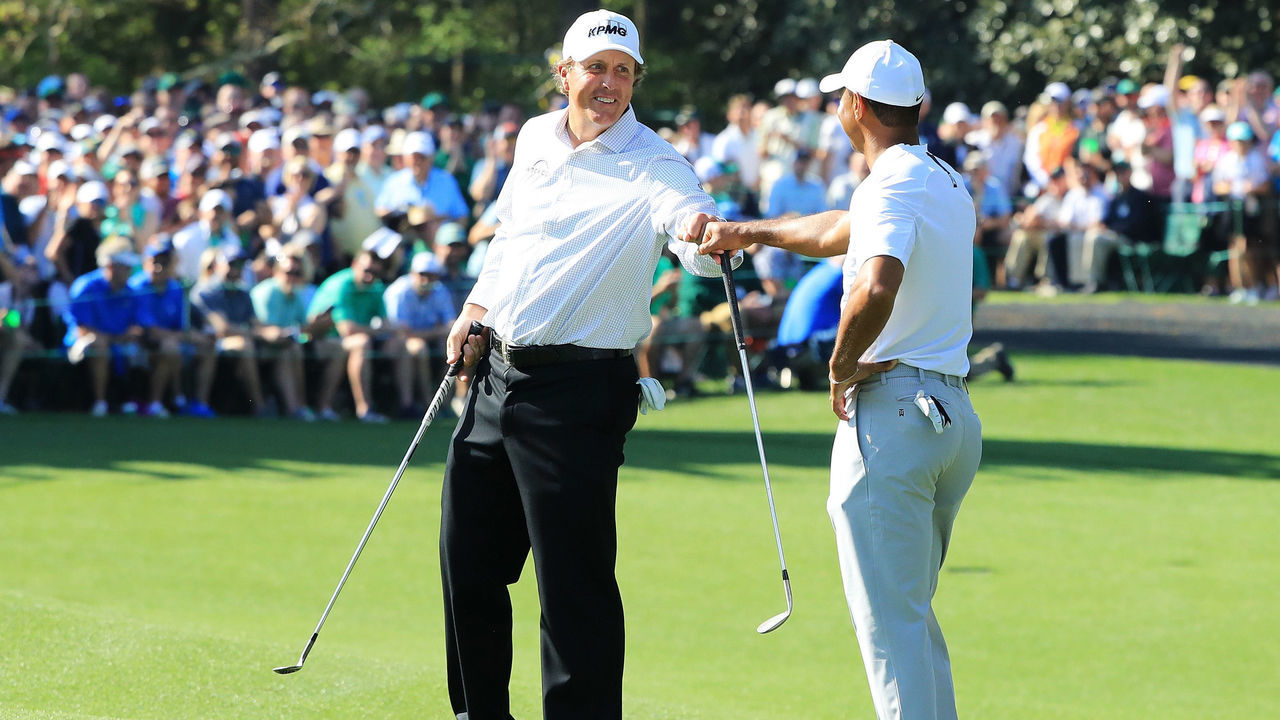 AUGUSTA, GA - APRIL 03: Tiger Woods and Phil Mickelson of the United States fist bump during a practice round prior to the start of the 2018 Masters Tournament at Augusta National Golf Club on April 3, 2018 in Augusta, Georgia.