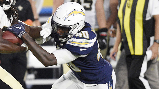 CARSON, CA - AUGUST 20: Running back Darius Victor #34 of the New Orleans Saints hangs on to the ball as defensive end Chris McCain #40 of the Los Angeles Chargers tries to strip it from him during the second half of a preseason football game against the New Orleans Saints at the StubHub Center August 20, 2017, in Carson, California.