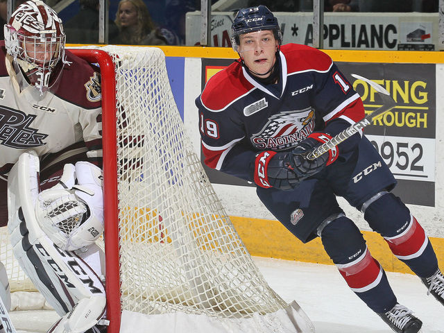 PETERBOROUGH, ON - OCTOBER 26: Blade Jenkins #19 of the Saginaw Spirit skates behind Dylan Wells #30 of the Peterborough Petes in an OHL game at the Peterborough Memorial Centre on October 26, 2017 in Peterborough, Ontario, Canada.