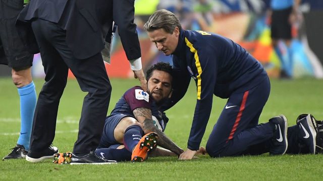 Paris Saint-Germain's Brazilian defender Daniel Alves (C) receives medical assistance during the French Cup final football match between Les Herbiers and Paris Saint-Germain (PSG), on May 8, 2018 at the Stade de France in Saint-Denis, outside Paris.