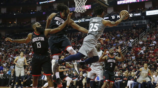 HOUSTON, TX - APRIL 15: Derrick Rose #25 of the Minnesota Timberwolves passes the ball under the basket against Nene Hilario #42 of the Houston Rockets and James Harden #13 in the second half during Game One of the first round of the 2018 NBA Playoffs at Toyota Center on April 15, 2018 in Houston, Texas.