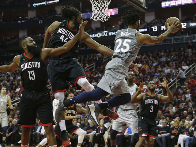HOUSTON, TX - APRIL 15: Derrick Rose #25 of the Minnesota Timberwolves passes the ball under the basket against Nene Hilario #42 of the Houston Rockets and James Harden #13 in the second half during Game One of the first round of the 2018 NBA Playoffs at Toyota Center on April 15, 2018 in Houston, Texas.