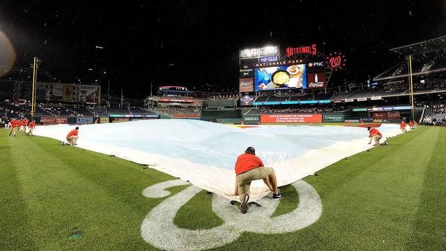 WASHINGTON, DC - MAY 15: The grounds crew puts the tarp on the field for a rain delay in the sixth inning in the game between the Washington Nationals and the New York Yankees at Nationals Park on May 15, 2018 in Washington, DC.