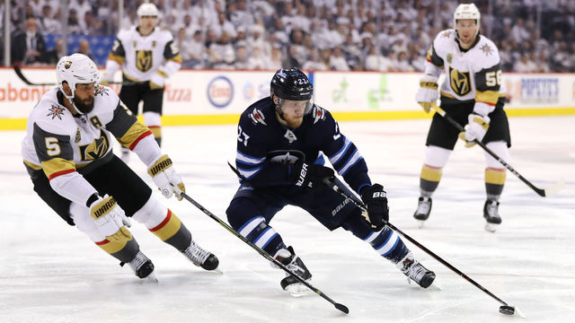 WINNIPEG, MB - MAY 12: Nikolaj Ehlers #27 of the Winnipeg Jets is defended by Deryk Engelland #5 of the Vegas Golden Knights during the second period in Game One of the Western Conference Finals during the 2018 NHL Stanley Cup Playoffs at Bell MTS Place on May 12, 2018 in Winnipeg, Canada.