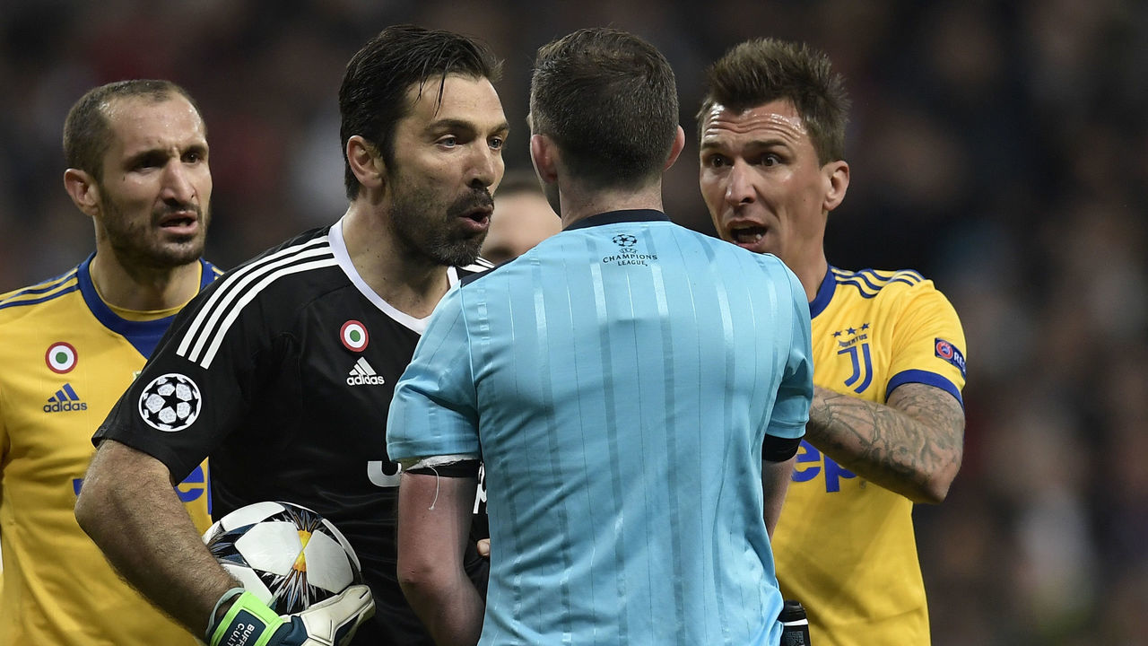 Juventus' Italian goalkeeper Gianluigi Buffon (2L) argues with the referee during the UEFA Champions League quarter-final second leg football match between Real Madrid CF and Juventus FC at the Santiago Bernabeu stadium in Madrid on April 11, 2018. / AFP PHOTO / OSCAR DEL POZO