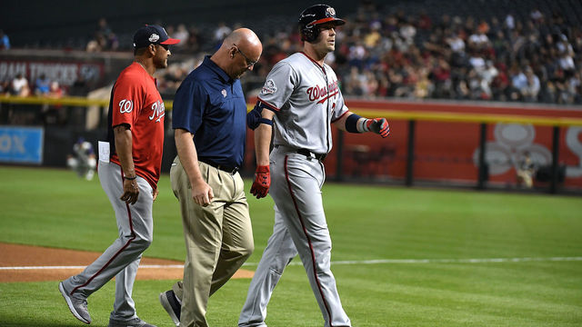 PHOENIX, AZ - MAY 10: Matt Wieters #32 of the Washington Nationals is helped off the field by director of athletic training Paul Lessard after injuring his leg rounding first base during the second inning against the Arizona Diamondbacks at Chase Field on May 10, 2018 in Phoenix, Arizona.