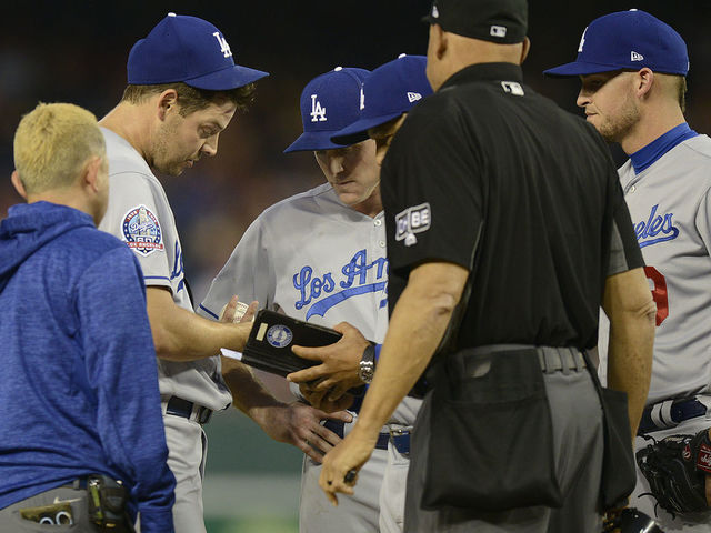WASHINGTON, DC - MAY 19: Rich Hill #44 of the Los Angeles Dodgers is checked out by the Los Angeles Dodgers staff in the first inning against the Washington Nationals at Nationals Park during game two of a doubleheader on May 19, 2018 in Washington, DC. Hill left the game after throwing two pitches.