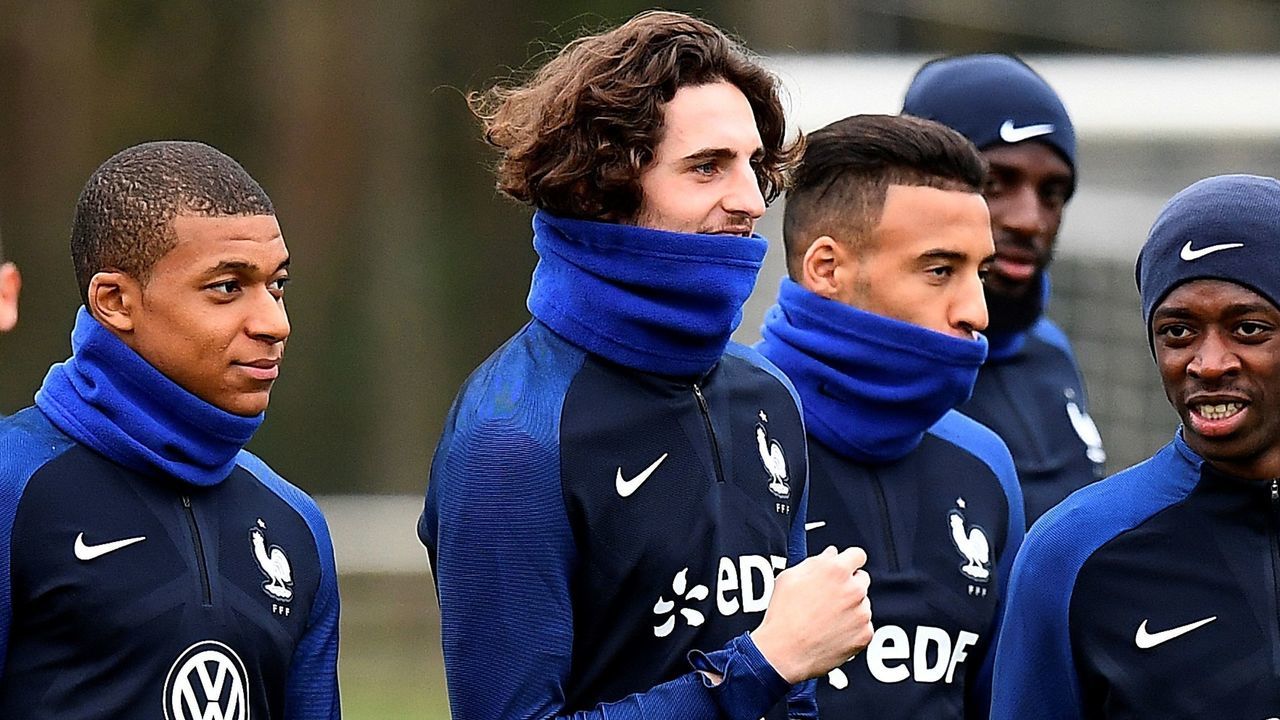 (From L) French national football team forward Kylian Mbappe walk with France's midfielder Adrien Rabiot and forward Ousmane Dembele as they arrive for a training session on March 20, 2017, in Clairefontaine near Paris as part of the team's preparation for the upcoming World Cup 2018 qualifiers. / AFP PHOTO / FRANCK FIFE