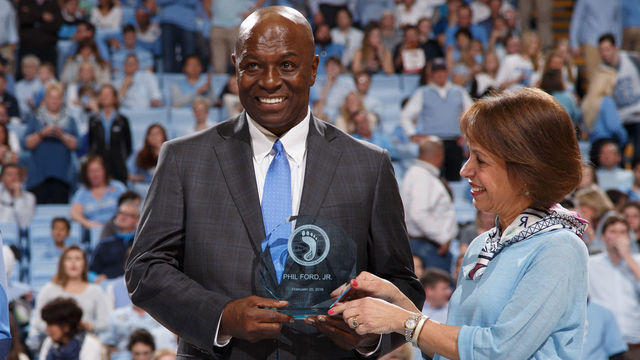 CHAPEL HILL, NC - FEBRUARY 20: North Carolina Tar Heel Phil Ford (center) awarded the Trailblazers Award by chancellor Carol Folt (R) during a game against the Miami Hurricanes on February 20, 2016 at the Dean E. Smith Center in Chapel Hill, North Carolina. North Carolina won 96-71.