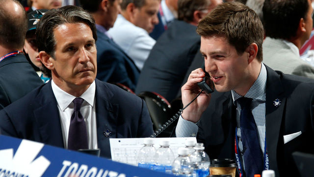 SUNRISE, FL - JUNE 26: Kyle Dubas Assistant General Manager of the Toronto Maple Leafs talks on the phone as President Brendan Shanahan looks on during the first round of the 2015 NHL Draft at BB&T Center on June 26, 2015 in Sunrise, Florida.