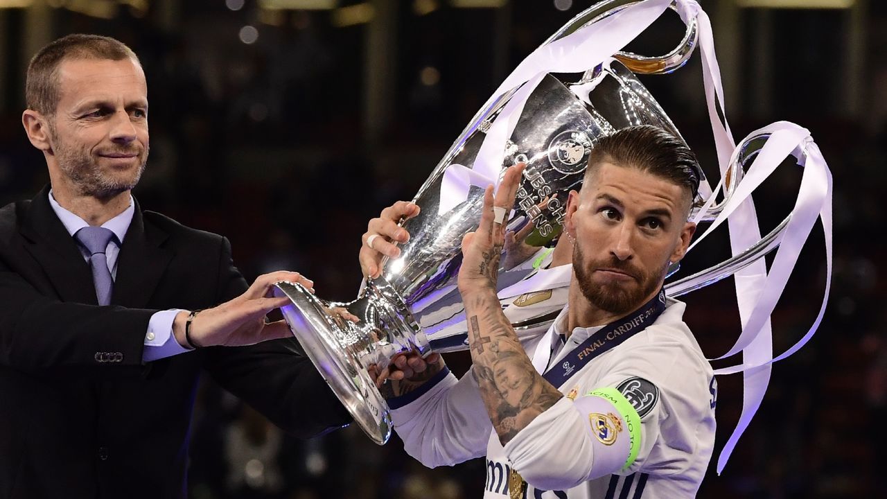 UEFA president Aleksander Ceferin (L) gives the trophy to Real Madrid captain Sergio Ramos (R) after Real Madrid won the UEFA Champions League final football match between Juventus and Real Madrid at The Principality Stadium in Cardiff, south Wales, on June 3, 2017. / AFP PHOTO / JAVIER SORIANO