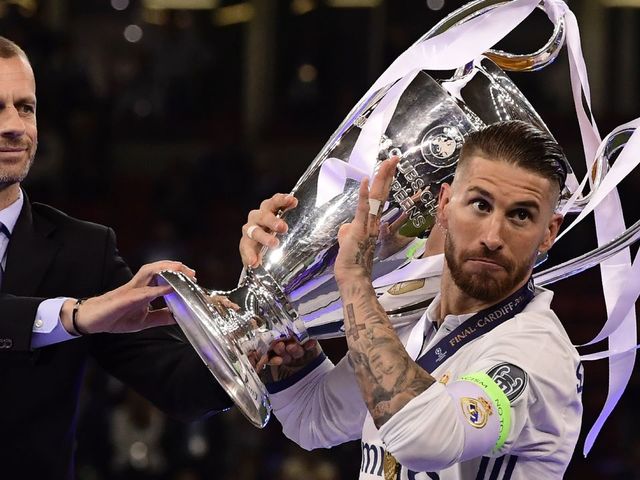 UEFA president Aleksander Ceferin (L) gives the trophy to Real Madrid captain Sergio Ramos (R) after Real Madrid won the UEFA Champions League final football match between Juventus and Real Madrid at The Principality Stadium in Cardiff, south Wales, on June 3, 2017. / AFP PHOTO / JAVIER SORIANO