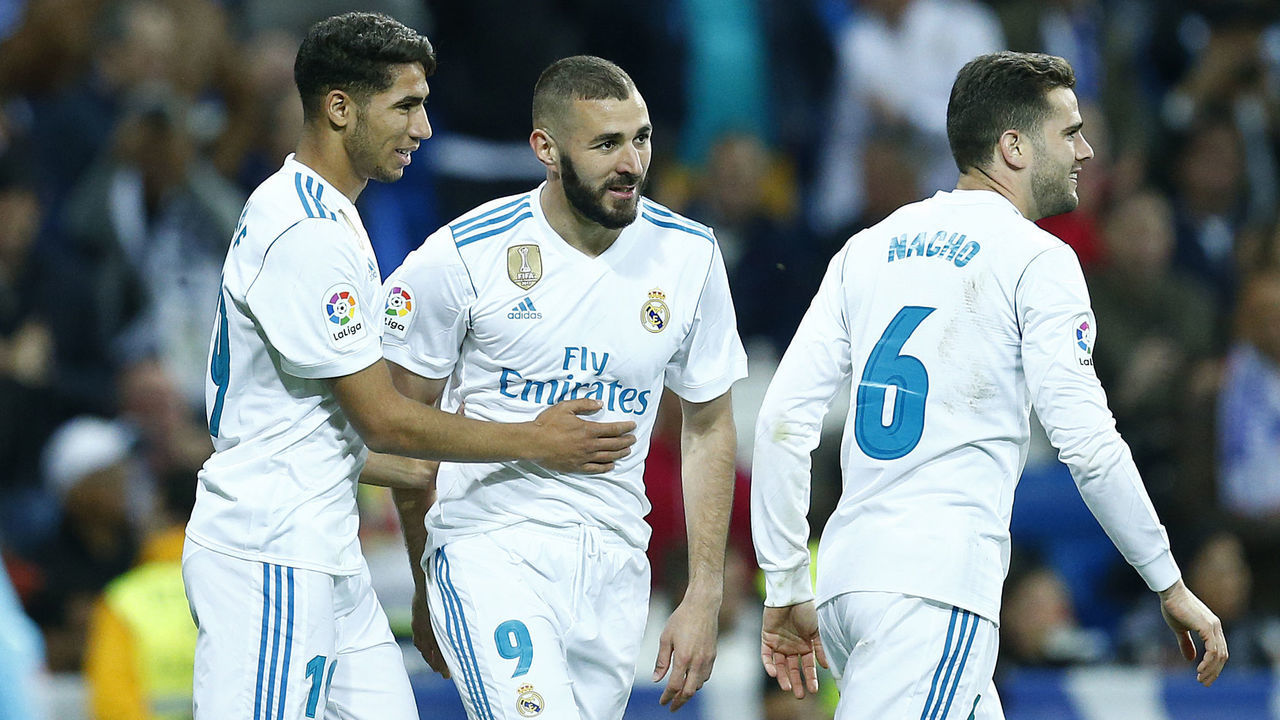 Real Madrid's Spanish-Moroccan defender Achraf Hakimi (L) celebrates a goal with Real Madrid's French forward Karim Benzema (C) and Real Madrid's Spanish defender Nacho Fernandez during the Spanish league football match between Real Madrid and Celta Vigo at the Santiago Bernabeu stadium in Madrid on May 12, 2018.