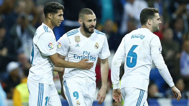 Real Madrid's Spanish-Moroccan defender Achraf Hakimi (L) celebrates a goal with Real Madrid's French forward Karim Benzema (C) and Real Madrid's Spanish defender Nacho Fernandez during the Spanish league football match between Real Madrid and Celta Vigo at the Santiago Bernabeu stadium in Madrid on May 12, 2018.