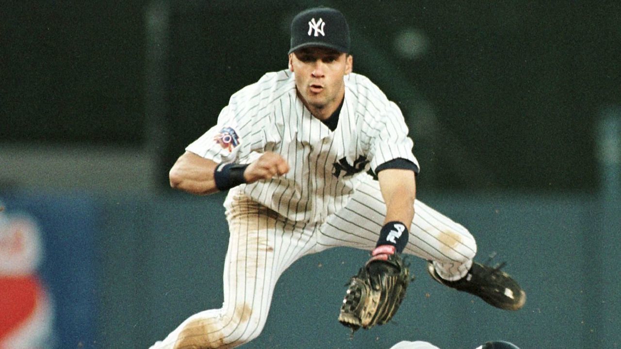 NEW YORK, UNITED STATES: New York Yankee shortstop Derek Jeter jumps to avoid a sliding Brian Giles of the Cleveland Indians as Giles is forced out at second base in the third inning of their game 27 June at Yankee Stadium in New York. Jeter's throw to first base got the Indians' Omar Vizquel out to complete the double play. AFP PHOTO/STAN HONDA