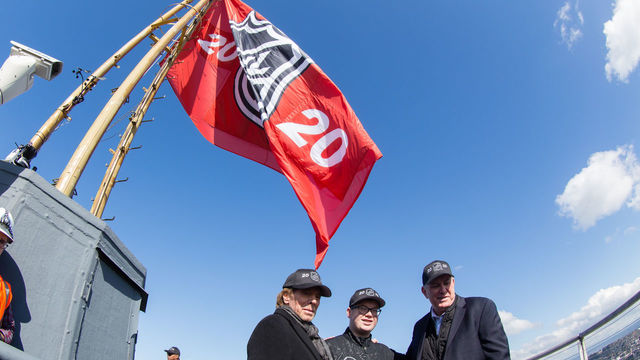 SEATTLE, WA - MARCH 1: Jerry Bruckheimer, honorary captain Bretton Chitwood (17) and Oak View Group Chief Executive Officer Tim Leiweke stand beneath the NHL 2020 flag on the top of the Space Needle during the NHL Seattle season ticket deposit drive kickoff on Thursday, March 1, 2018 in Seattle, WA.