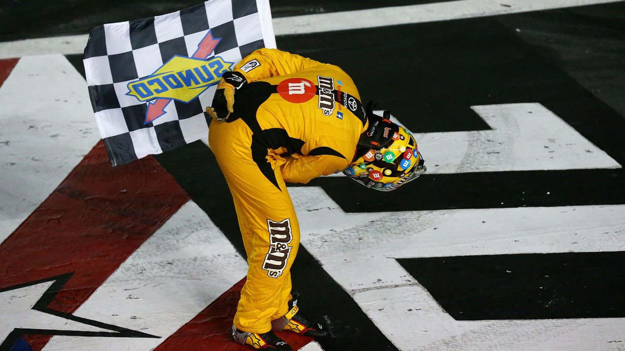 CHARLOTTE, NC - MAY 27: Kyle Busch, driver of the #18 M&M's Red White & Blue Toyota, celebrates with the checkered flag after winning the Monster Energy NASCAR Cup Series Coca-Cola 600 at Charlotte Motor Speedway on May 27, 2018 in Charlotte, North Carolina.