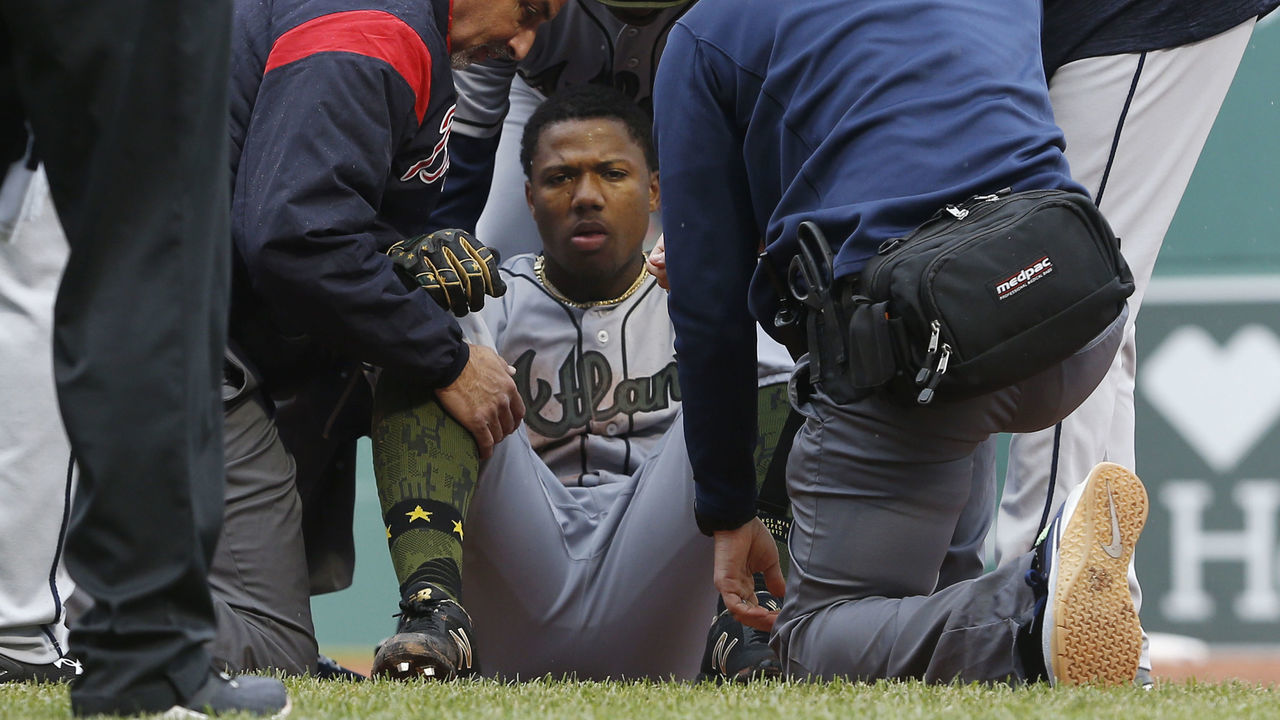 BOSTON, MA - MAY 27: Braves Ronald Acuna Jr. is helped up after taking a nasty fall at first base during the seventh inning of a game between the Boston Red Sox and Atlanta Braves at Fenway Park in Boston on May 27, 2018.