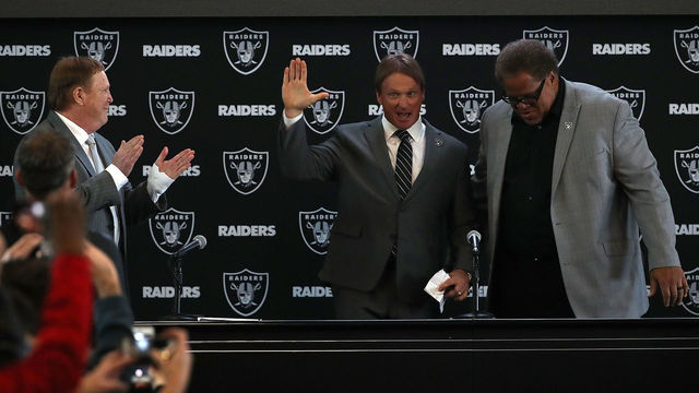 ALAMEDA, CA - JANUARY 09: Oakland Raiders new head coach Jon Gruden (C) waves to attendees during a news conference at Oakland Raiders headquarters on January 9, 2018 in Alameda, California. Jon Gruden has returned to the Oakland Raiders after leaving the team in 2001.