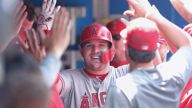 TORONTO, ON - MAY 24: Mike Trout #27 of the Los Angeles Angels of Anaheim is congratulated by teammates in the dugout after hitting a solo home run in the fifth inning during MLB game action against the Toronto Blue Jays at Rogers Centre on May 24, 2018 in Toronto, Canada.