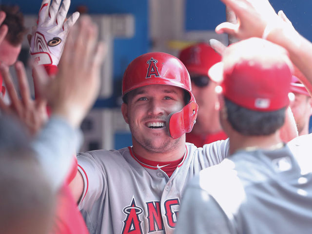 TORONTO, ON - MAY 24: Mike Trout #27 of the Los Angeles Angels of Anaheim is congratulated by teammates in the dugout after hitting a solo home run in the fifth inning during MLB game action against the Toronto Blue Jays at Rogers Centre on May 24, 2018 in Toronto, Canada.