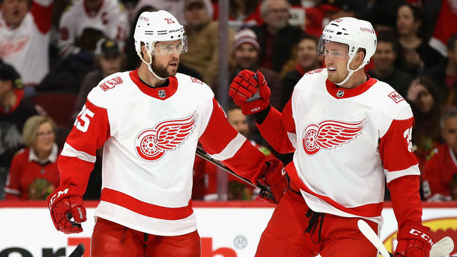 CHICAGO, IL - JANUARY 14: Mike Green #25 of the Detroit Red Wings (center) is greeted by Niklas Kronwall #55 and Anthony Mantha #39 of the Detroit Red Wings after scoring a first period goal against the Chicago Blackhawks at the United Center on January 14, 2018 in Chicago, Illinois.