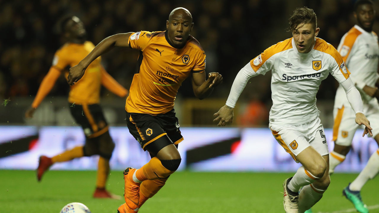 WOLVERHAMPTON, ENGLAND - APRIL 03: Benik Afobe of Wolverhampton Wanderers controls the ball watched by Angus MacDonald during the Sky Bet Championship match between Wolverhampton Wanderers and Hull City at Molineux on April 3, 2018 in Wolverhampton, England.