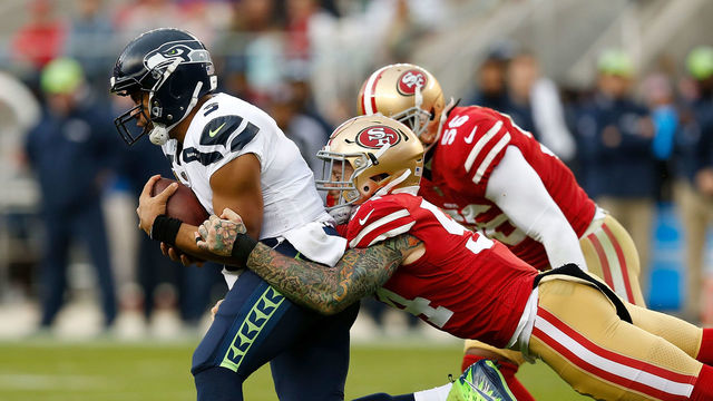 SANTA CLARA, CA - NOVEMBER 26: Quarterback Russell Wilson #75 of the Seattle Seahawks is tackled by Cassius Marsh #54 of the San Francisco 49ers at Levi's Stadium on November 26, 2017 in Santa Clara, California.