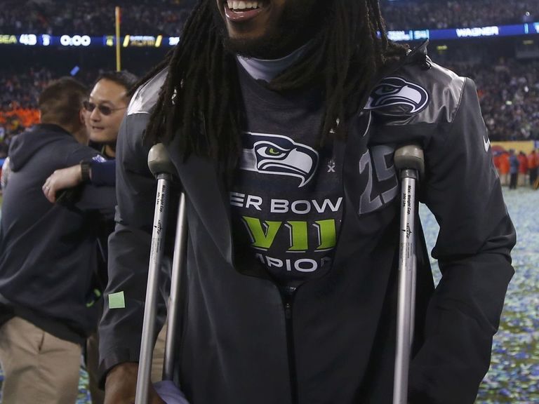 Seattle Seahawks cornerback Richard Sherman (25) gets looked over by the  Seattle medical staff as Denver Broncos quarterback Peyton Manning (18)  walks past at the Super Bowl XLVIII at MetLife Stadium in