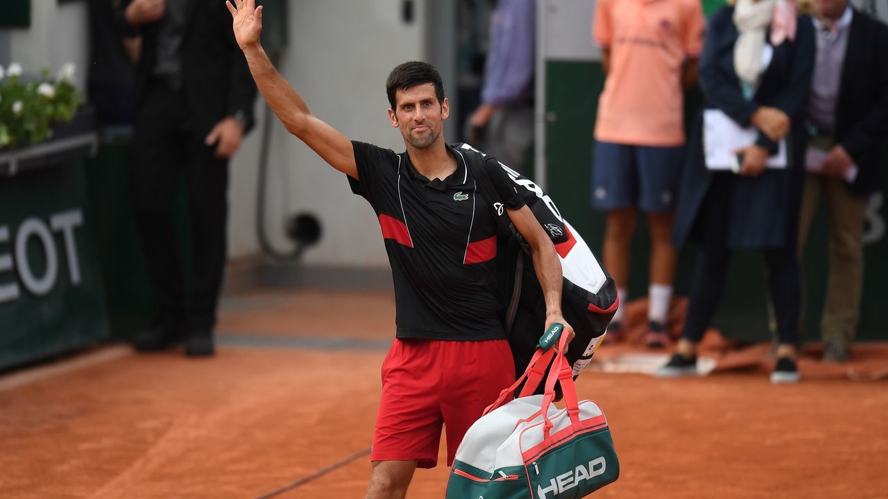 TOPSHOT - Serbia's Novak Djokovic waves to spectators as he leaves the court after his defeat by Italy's Marco Cecchinato during their men's singles quarter-final match on day ten of The Roland Garros 2018 French Open tennis tournament in Paris on June 5, 2018.