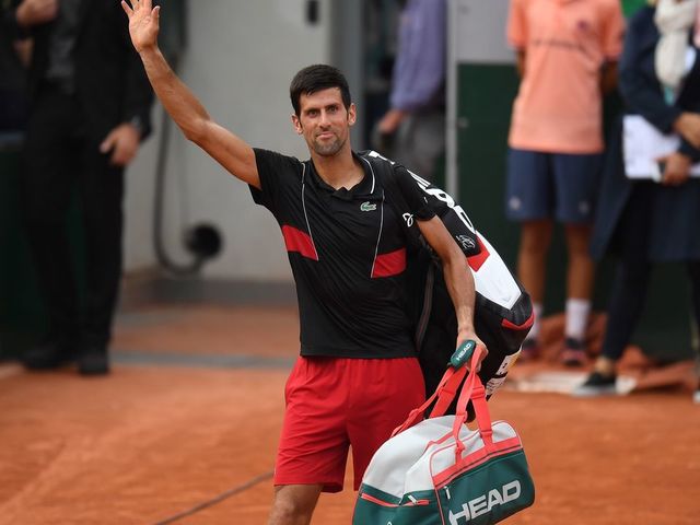 TOPSHOT - Serbia's Novak Djokovic waves to spectators as he leaves the court after his defeat by Italy's Marco Cecchinato during their men's singles quarter-final match on day ten of The Roland Garros 2018 French Open tennis tournament in Paris on June 5, 2018.