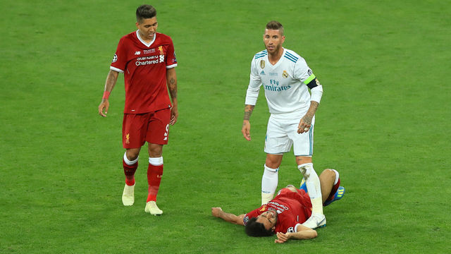 Real Madrd's Garcia Sergio Ramos stands over Liverpool's Mohamed Salah after a challenge as Liverpool's Roberto Firmino (left) looks on during the UEFA Champions League Final at the NSK Olimpiyskiy Stadium, Kiev.