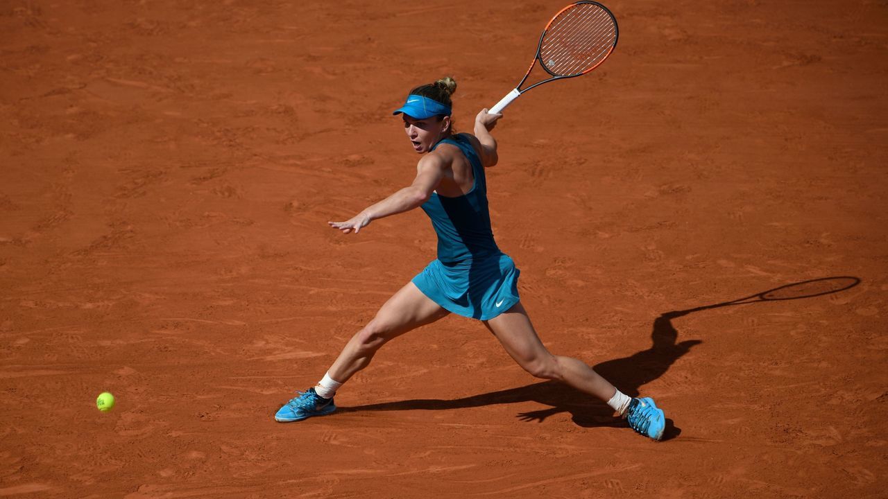 TOPSHOT - Spain's Garbine Muguruza returns the ball to Romania's Simona Halep during their women's singles semi-final match on day twelve of The Roland Garros 2018 French Open tennis tournament in Paris on June 7, 2018.