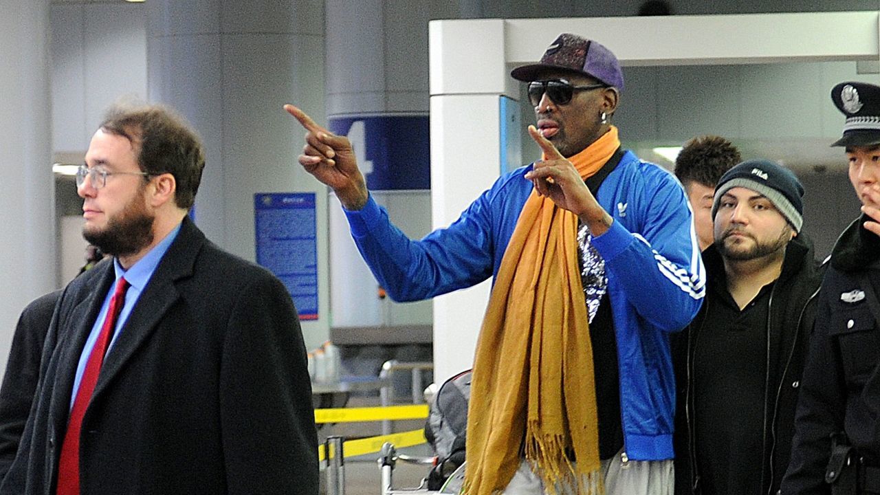 Former US basketball player Dennis Rodman gestures as he arrives at Beijing International Airport from North Korea on January 13, 2014. Rodman returned to China from Pyongyang after a seven-day trip where he sang 'Happy birthday to you!' to North Korean leader Kim Jong-Un on January 8. AFP PHOTO / WANG ZHAO