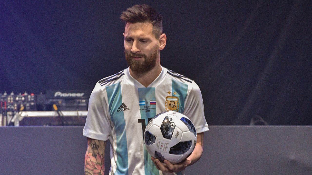 TOPSHOT - Barcelona and Argentina forward Lionel Messi poses with the official match ball for the 2018 World Cup football tournament, named 'Telstar 18', during its unveiling ceremony in Moscow on November 9, 2017. / AFP PHOTO / Mladen ANTONOV
